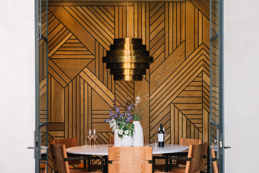 Intimate VIP dining room with geometric wood wall detail at Sinegal Estate